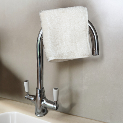 White bamboo dish cloth on tap over kitchen sink