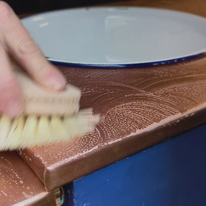 woman cleaning worktop with general wooden cleaning brush